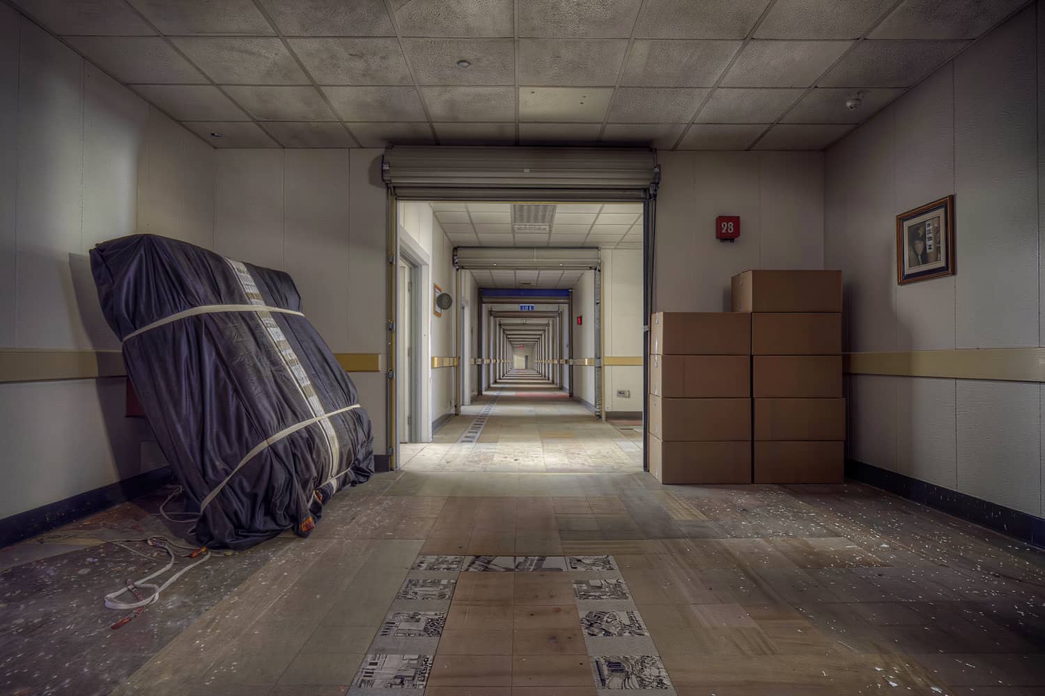 Inside a clean storage unit part loaded with blanket-wrapped furniture and plain stacked cartons