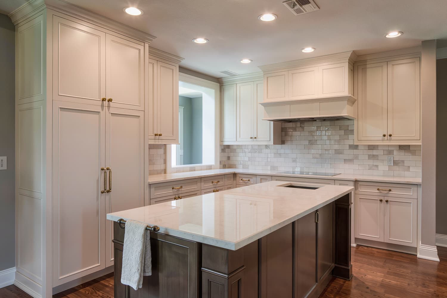 Finished kitchen with inset painted cabinetry, a mitred quartz island edge and bare counters