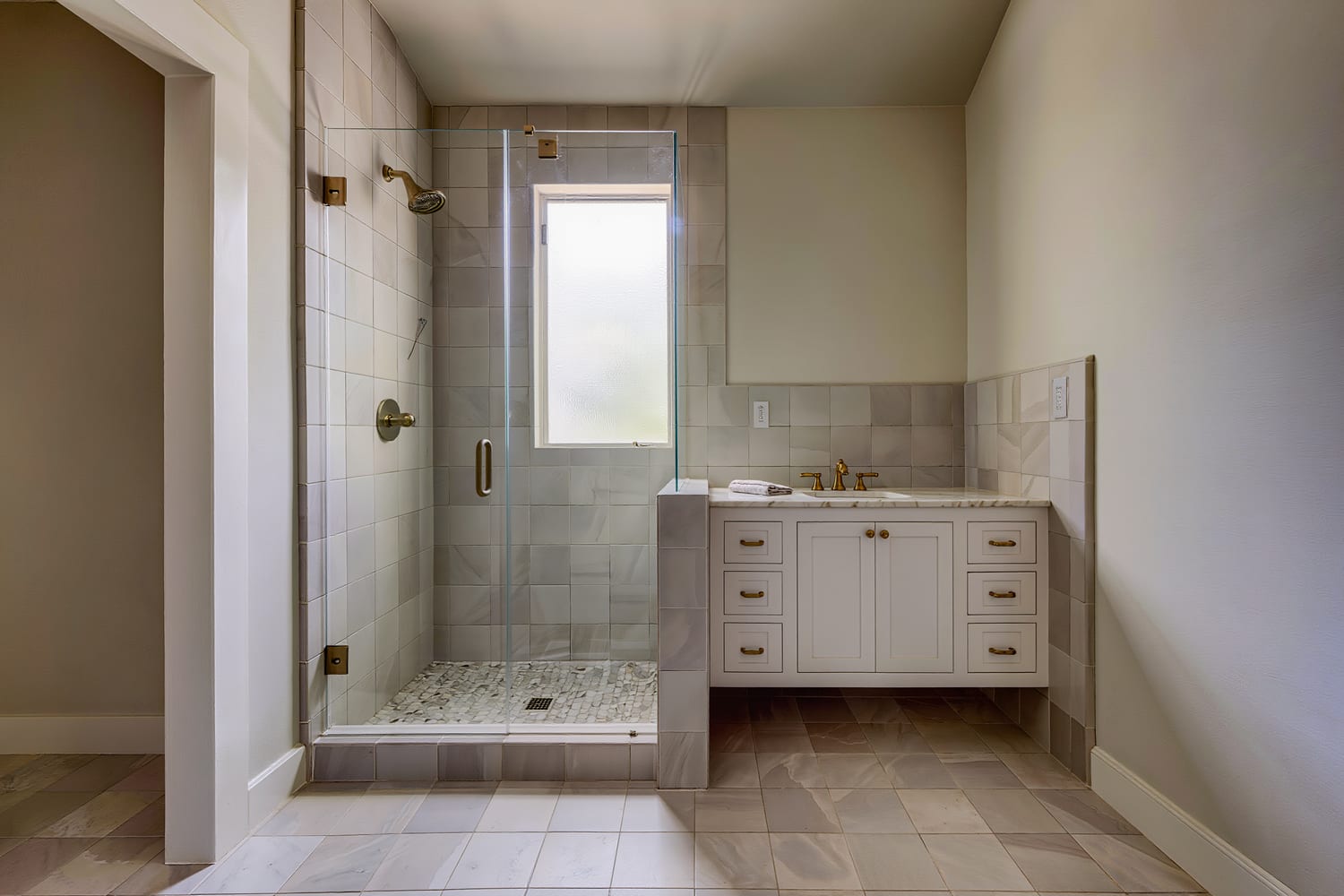 Primary bathroom with a curbless tiled shower, floating oak vanity and a high frosted window