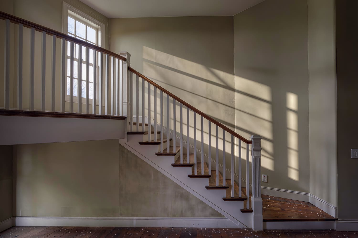 Rebuilt stair with white oak treads, painted risers and square balusters below a landing window