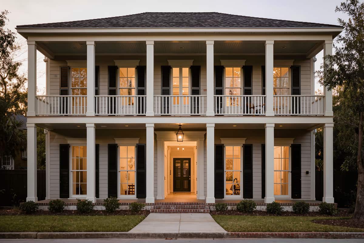 Completed front elevation of a house with lap siding and a deep two tier porch at golden hour
