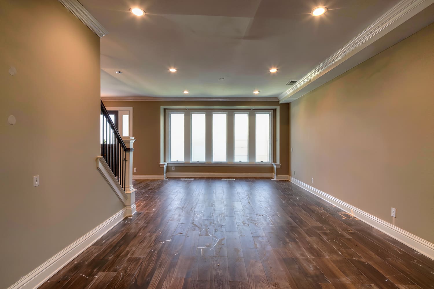 Finished lower level living room with a level ceiling, recessed downlights and a built in bench
