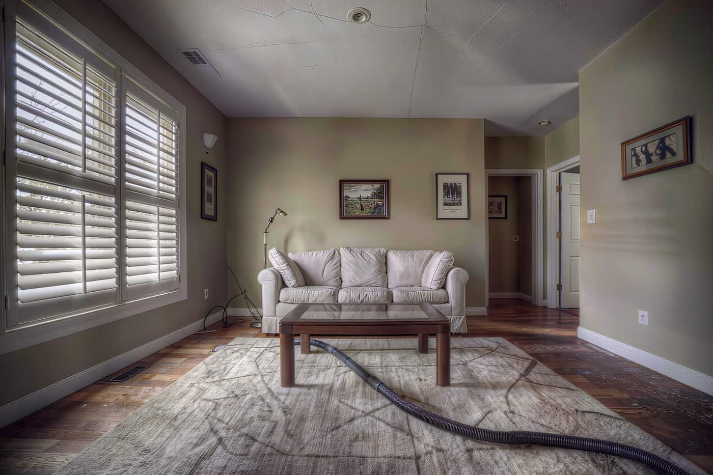 Freshly cleaned living room in early morning light with squared cushions and half-open plantation shutters