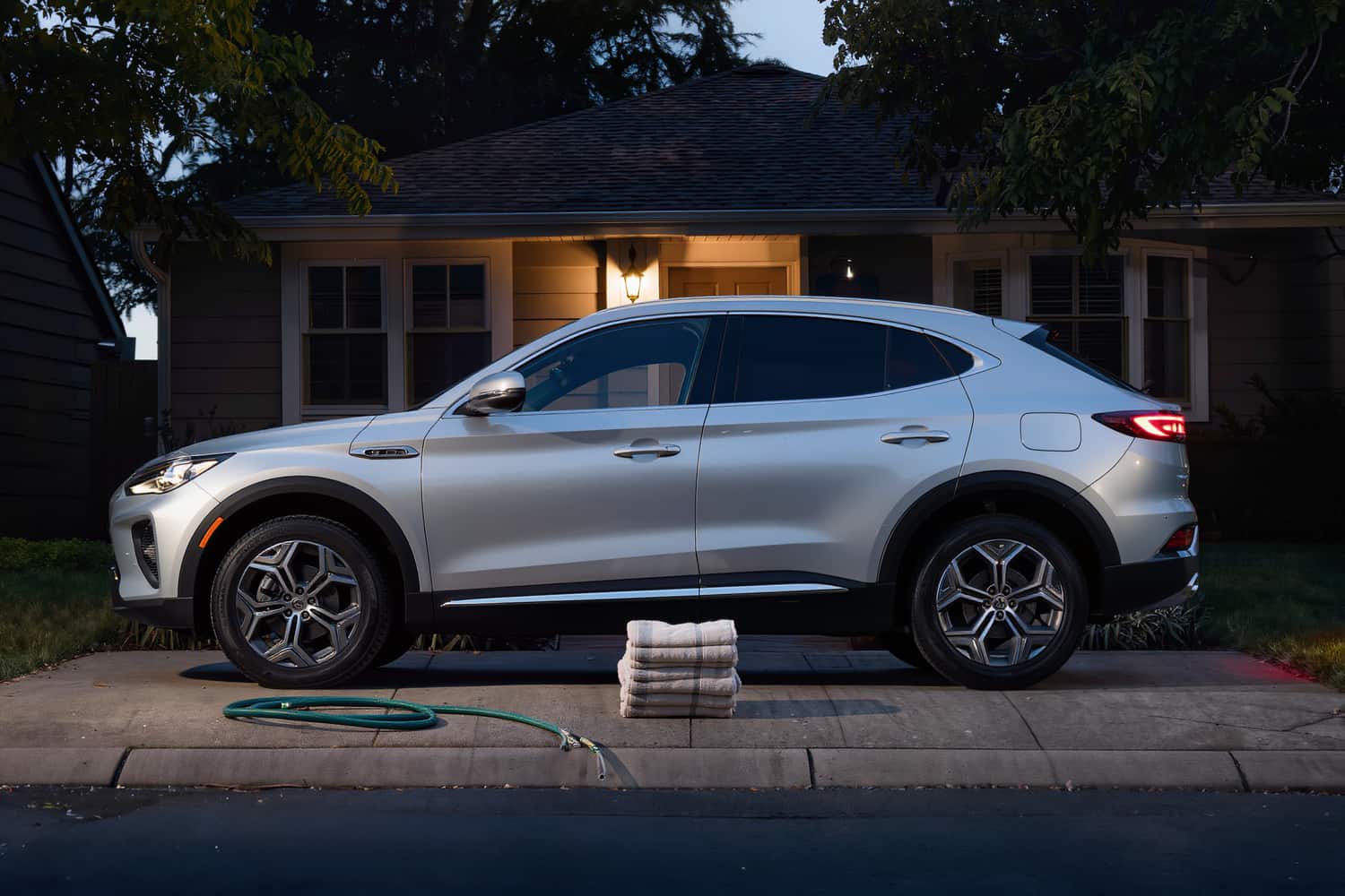 A freshly detailed silver crossover parked on a suburban driveway at dusk