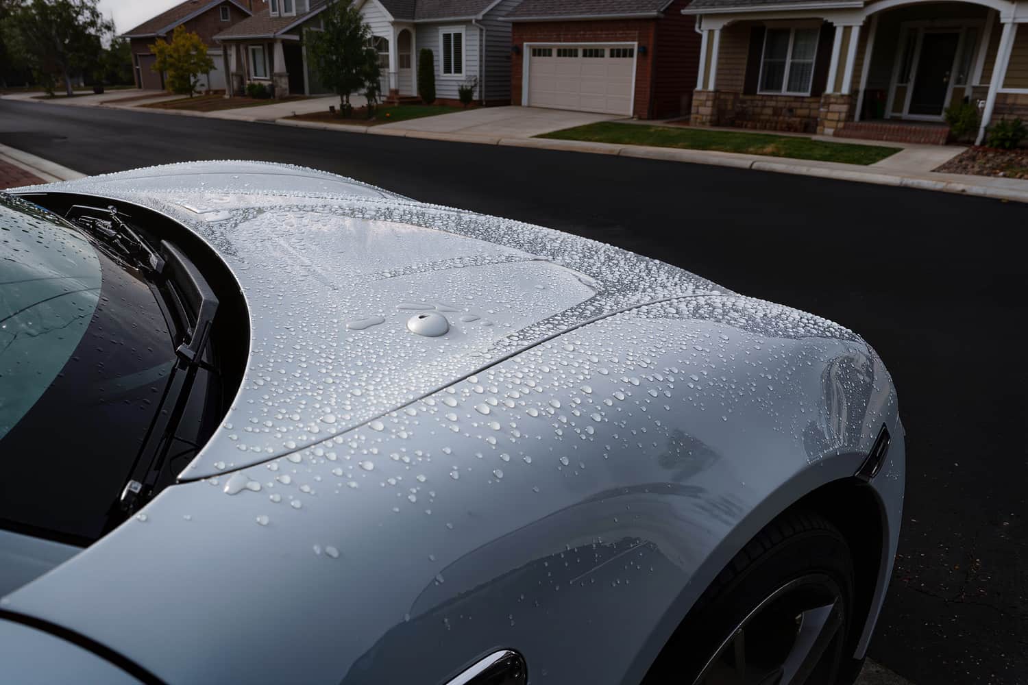 Tight water beading standing on the ceramic coated hood of a coupe
