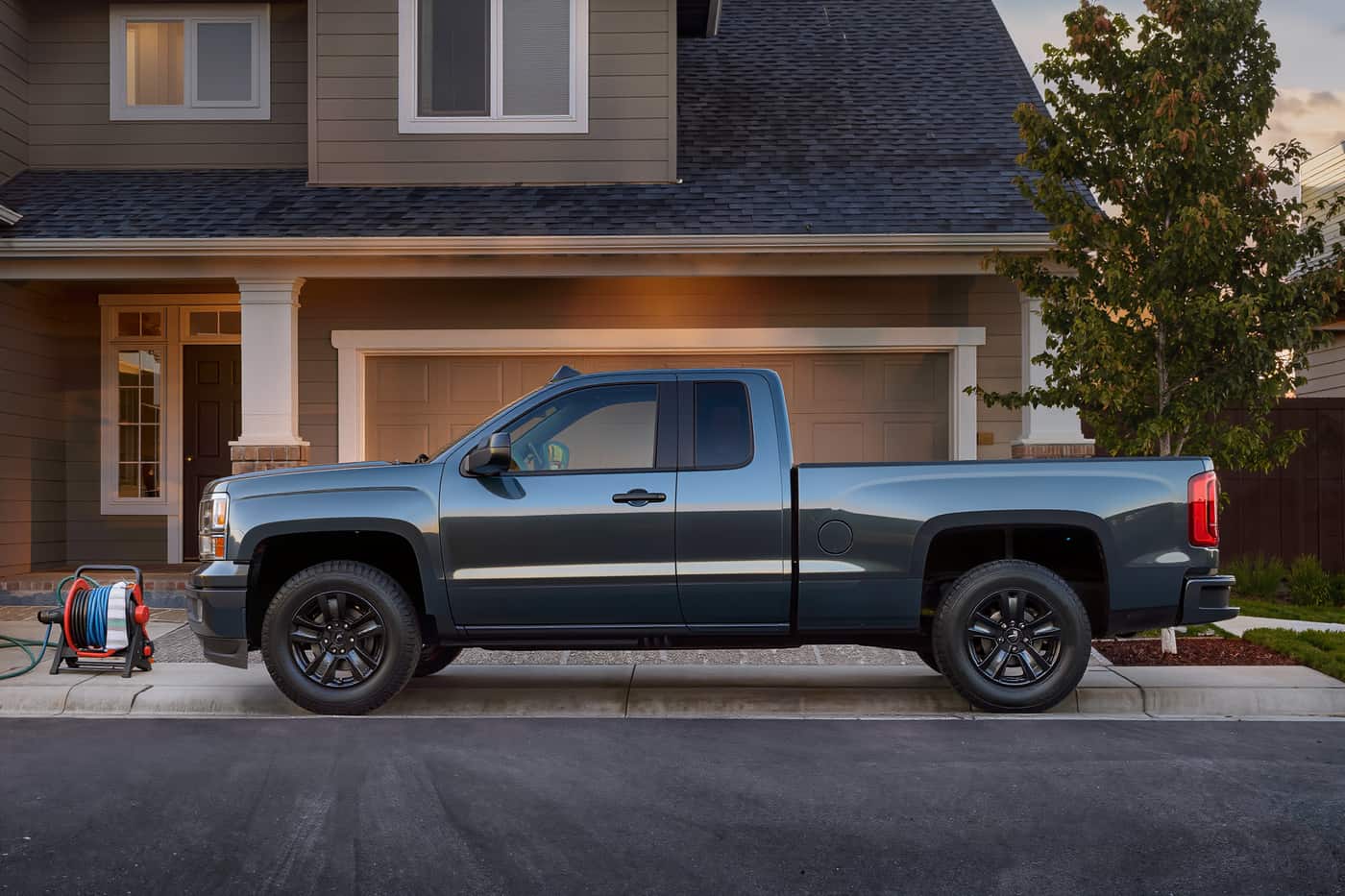 Full-size pickup in side profile on a driveway just after an exterior wash