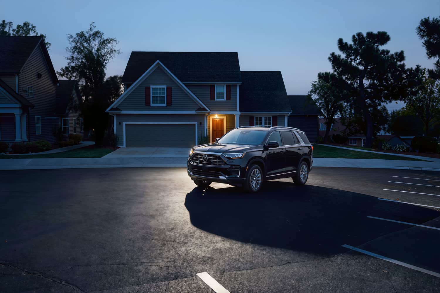 Polished black SUV at a three-quarter angle across an empty apron at blue hour