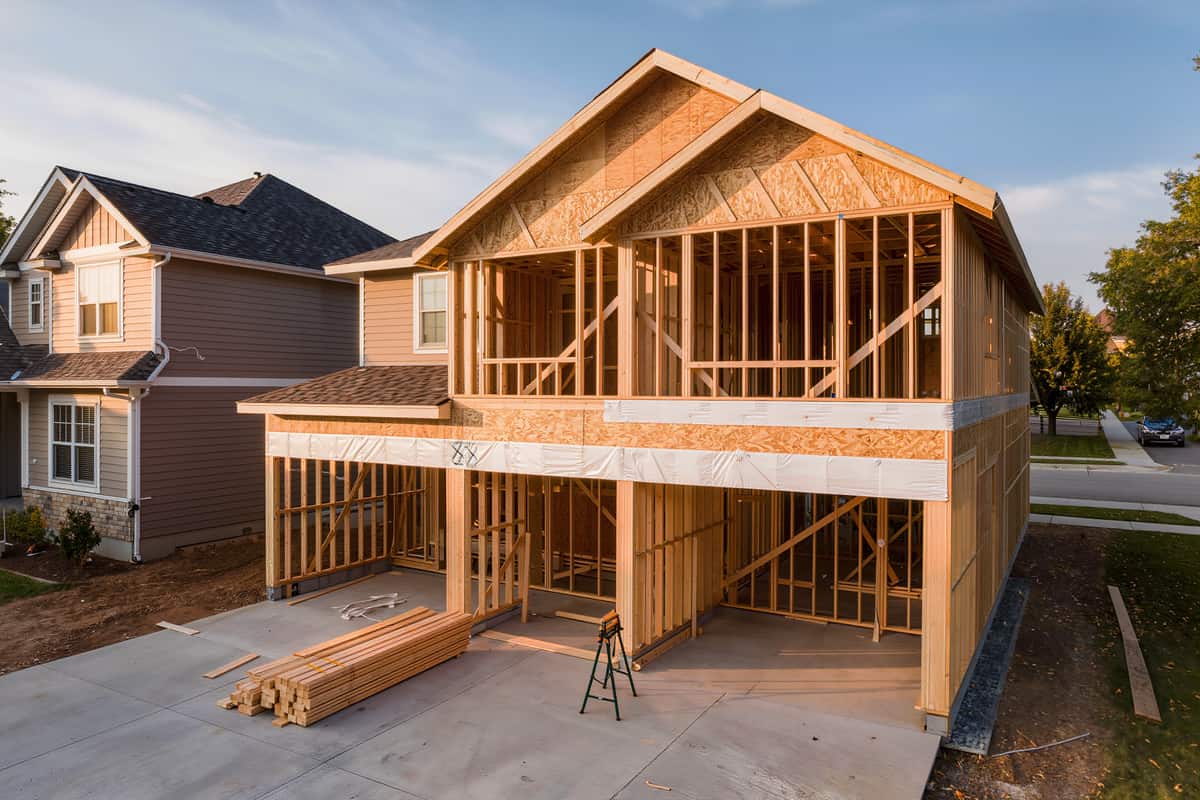 Two-storey rear addition at the framing stage with exposed studs, joists and part-hung sheathing