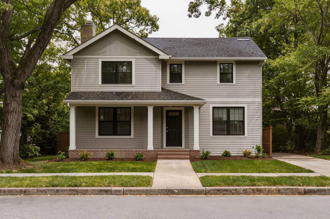 Completed two-storey home exterior in fresh lap siding seen straight on from across the street