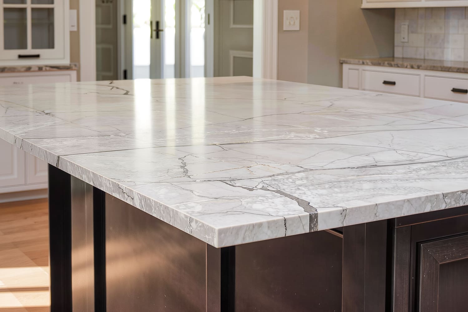 Close detail of a quartz waterfall island end with the veining running over the mitred corner