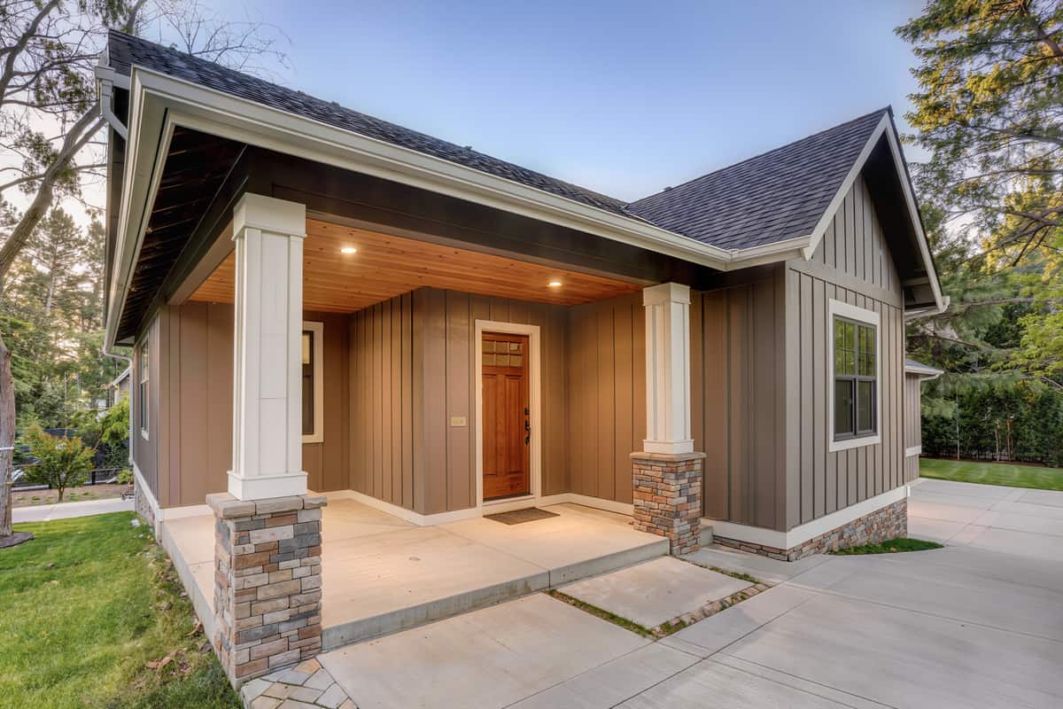 Low close view of a new custom home entry porch where board-and-batten meets lap siding