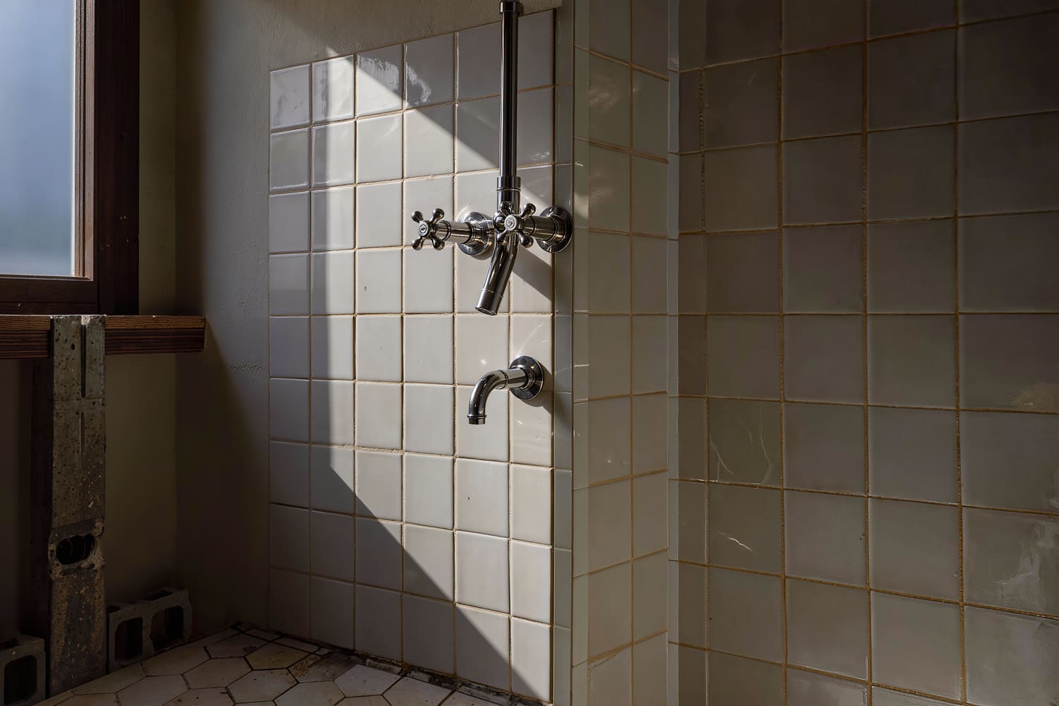 Close detail of tile, grout and a new fixture in a finished apartment bathroom.