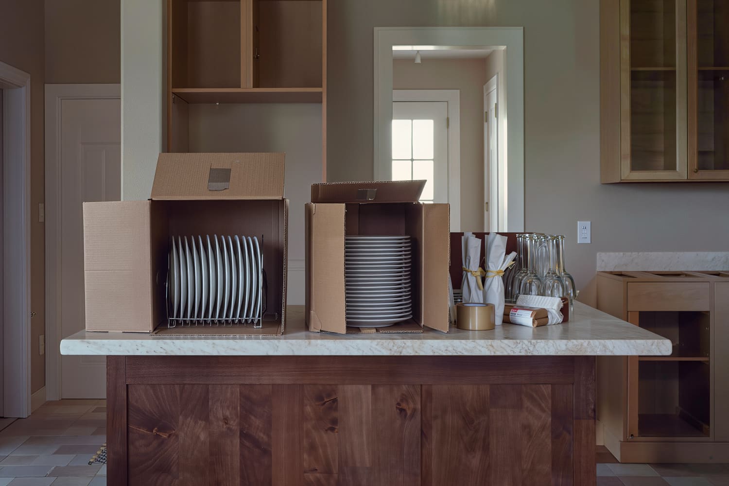 Cartons and wrapped kitchenware staged on a kitchen island before loading.