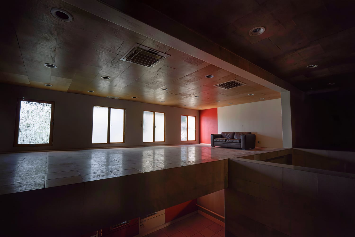 Grid of flush recessed downlights washing a living room ceiling in the evening