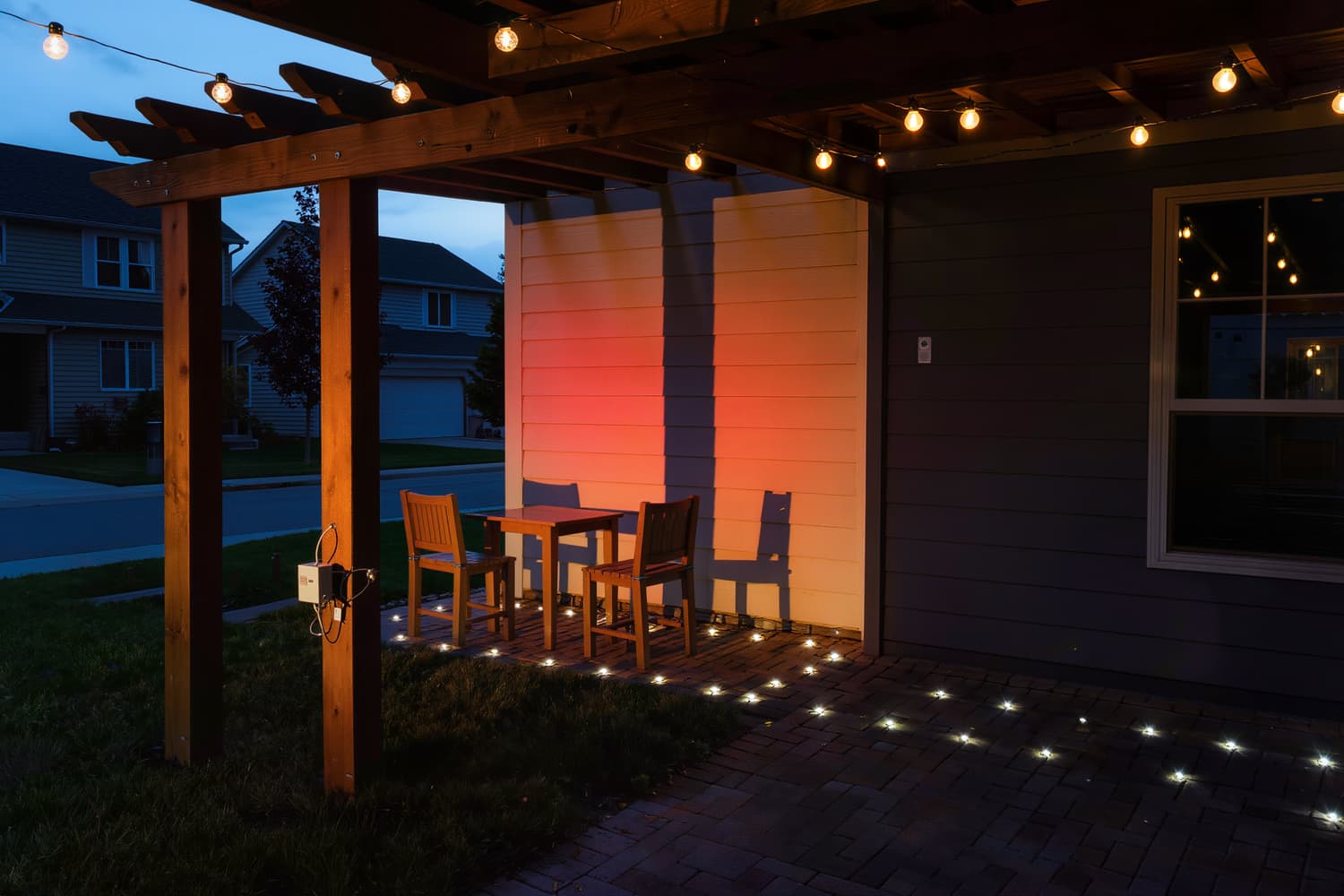 Path lights and pergola string lights on a backyard patio at dusk