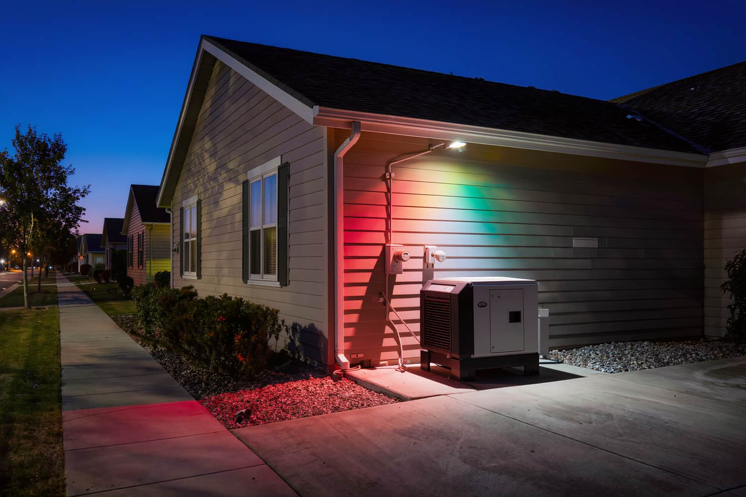 Transfer switch on lap siding beside a standby generator on a concrete pad