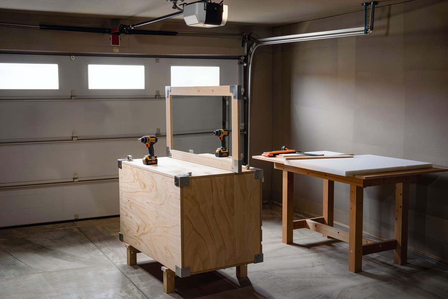 Custom plywood crate built around a wrapped mirror and closed with corner braces in a garage