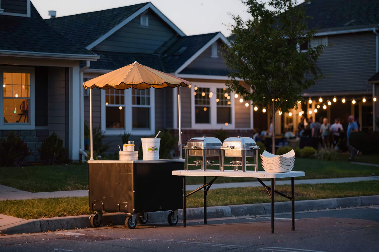 Cart set up for catering at a block party with chafing trays on a trestle table