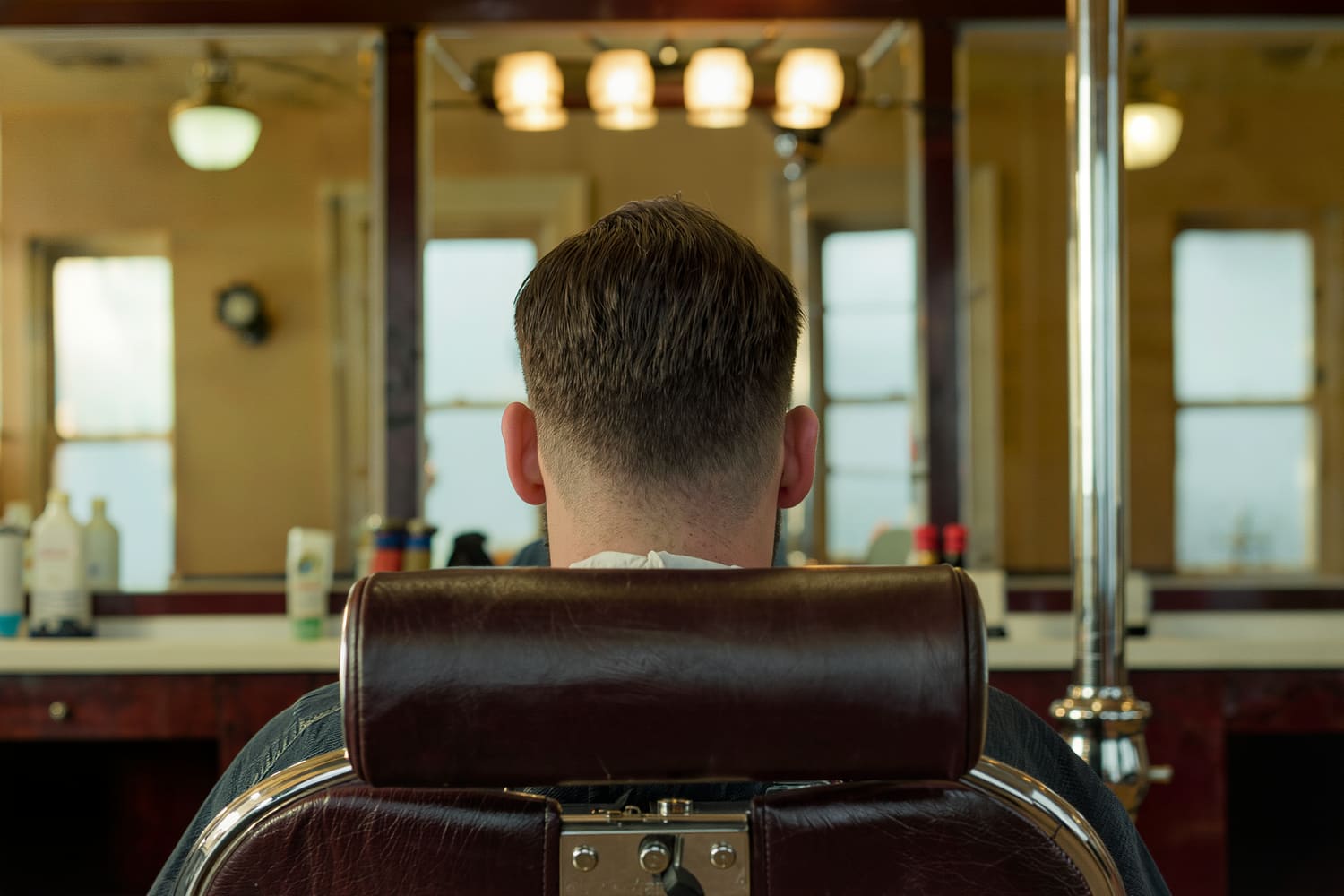 Clean tapered skin fade and razored neckline seen from directly behind the chair