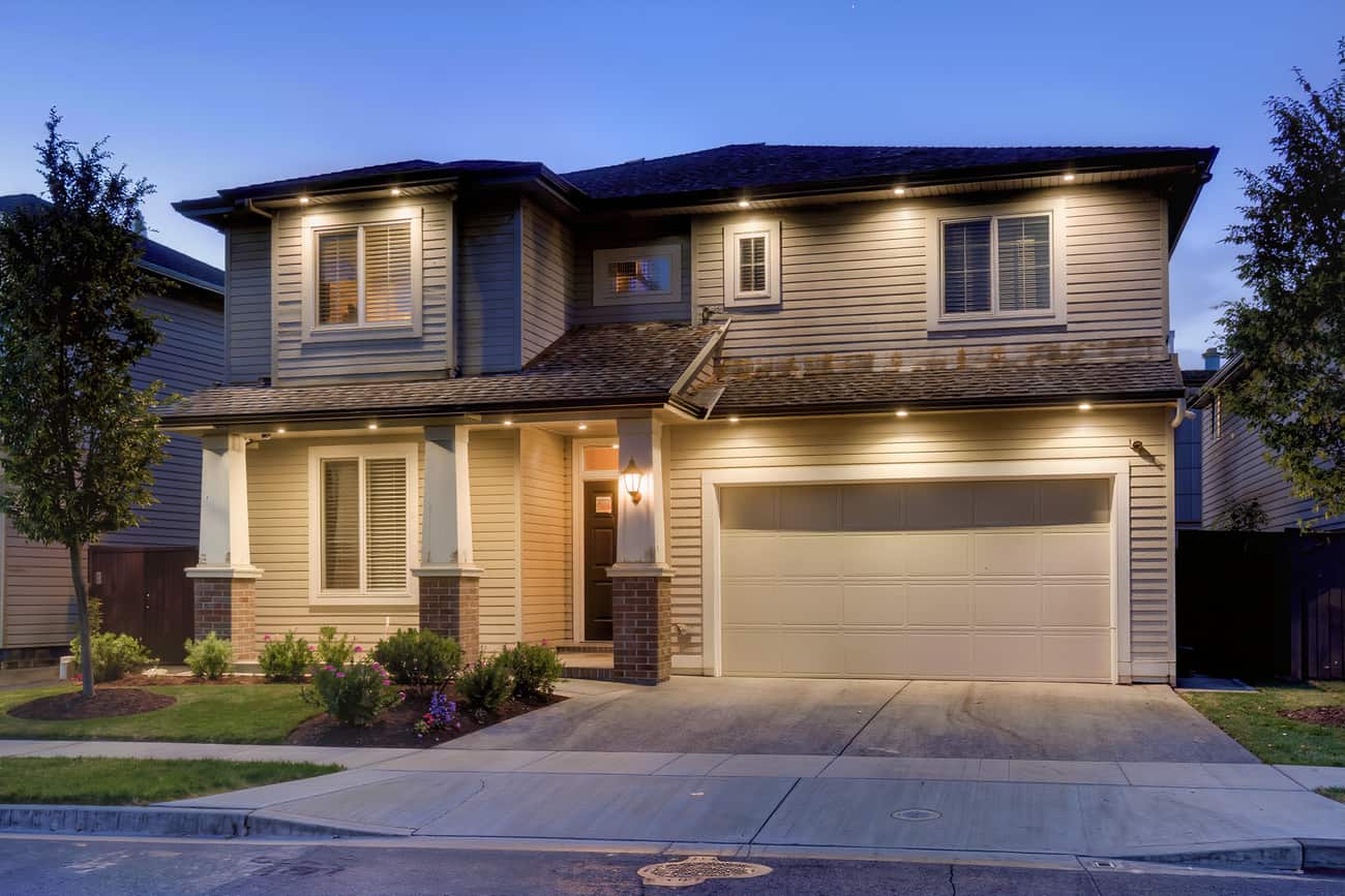 Front elevation of a suburban house at blue hour with soffit and column lighting on