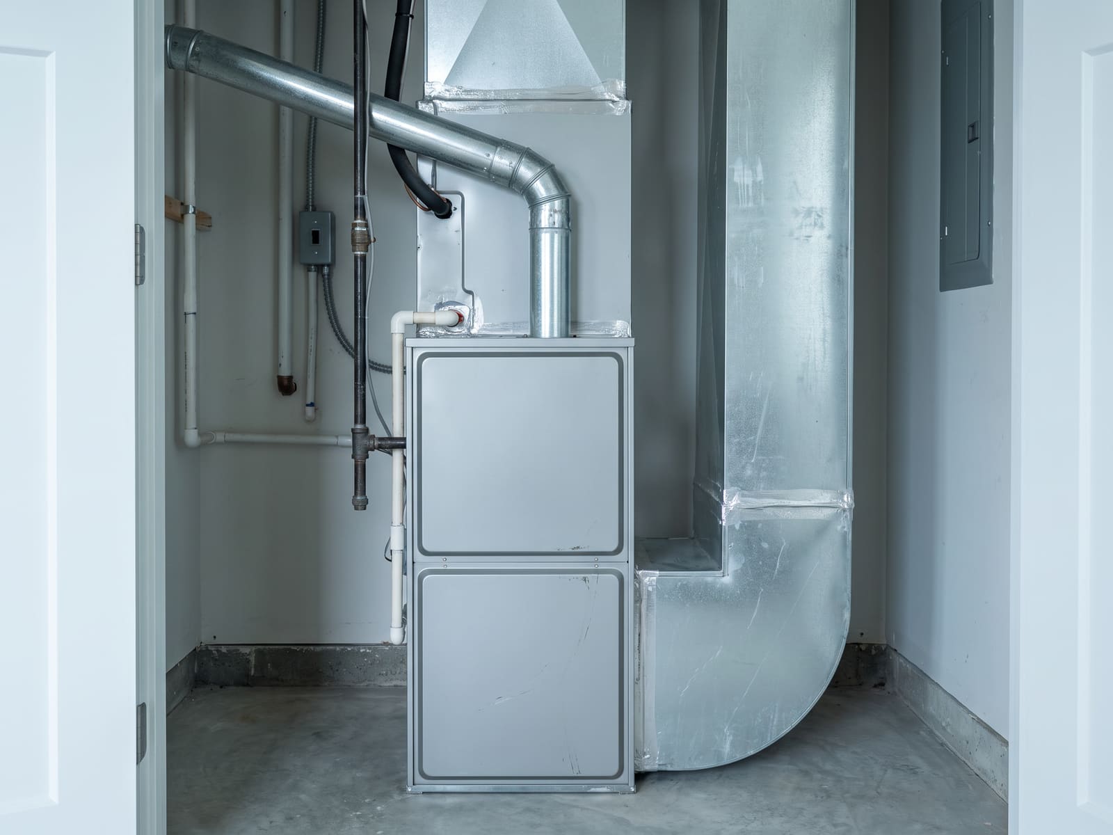 Furnace installed in a utility space with sealed plenum transitions and a correctly pitched flue