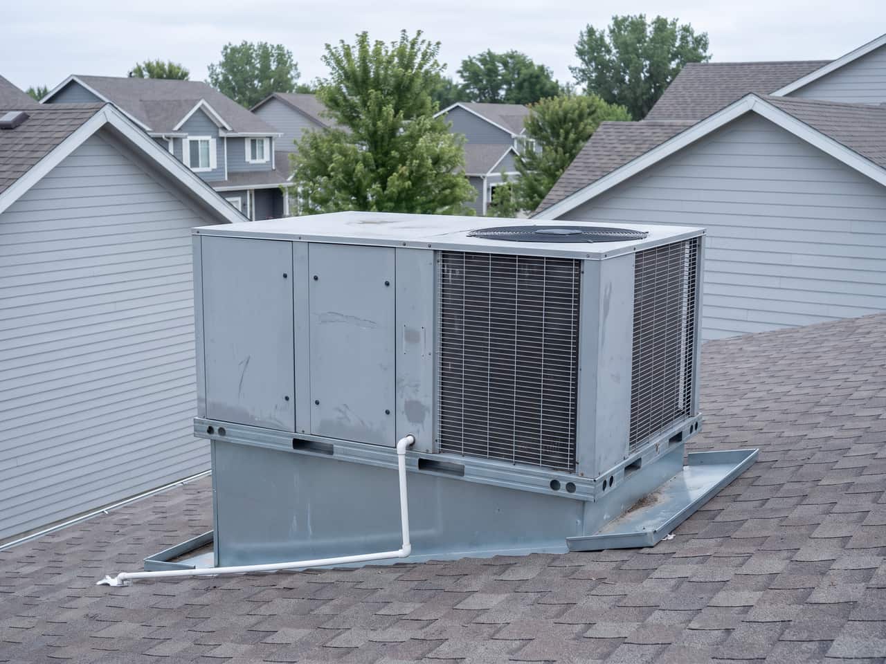 Packaged rooftop unit on a flashed curb with panels closed and condensate routed to drain