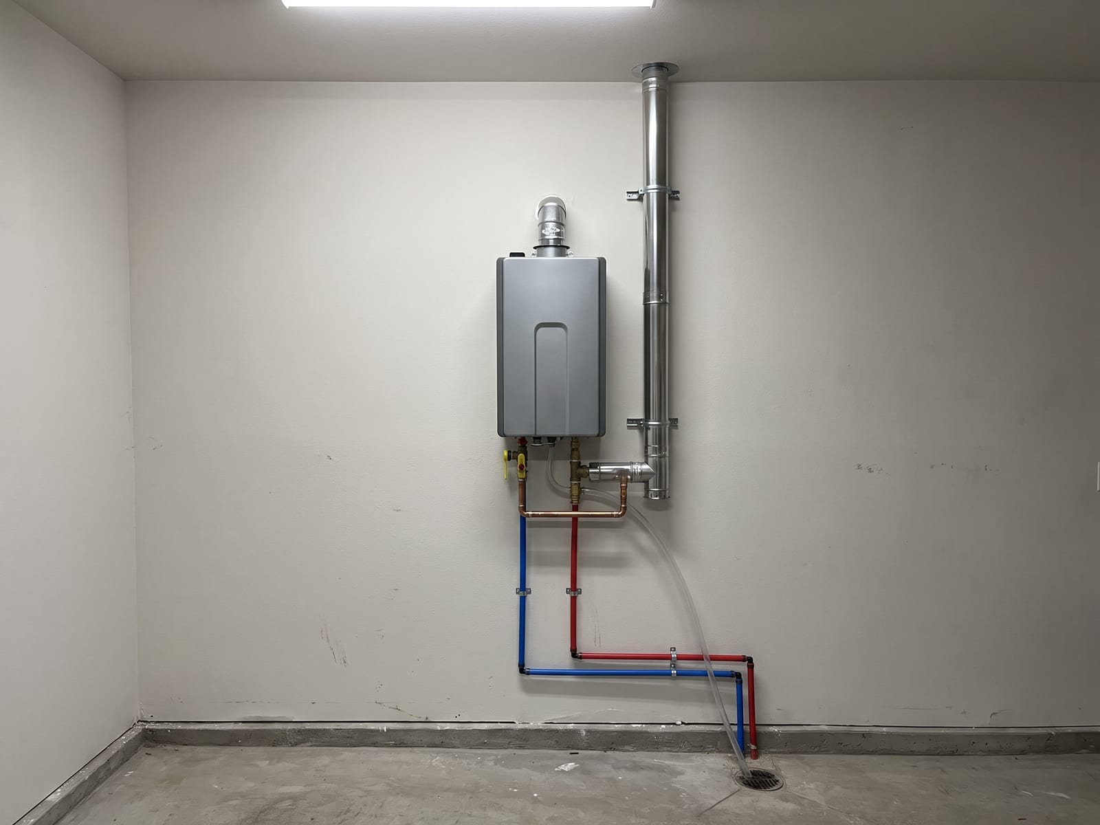 Wall-mounted tankless water heater installed level with isolation valves and vent