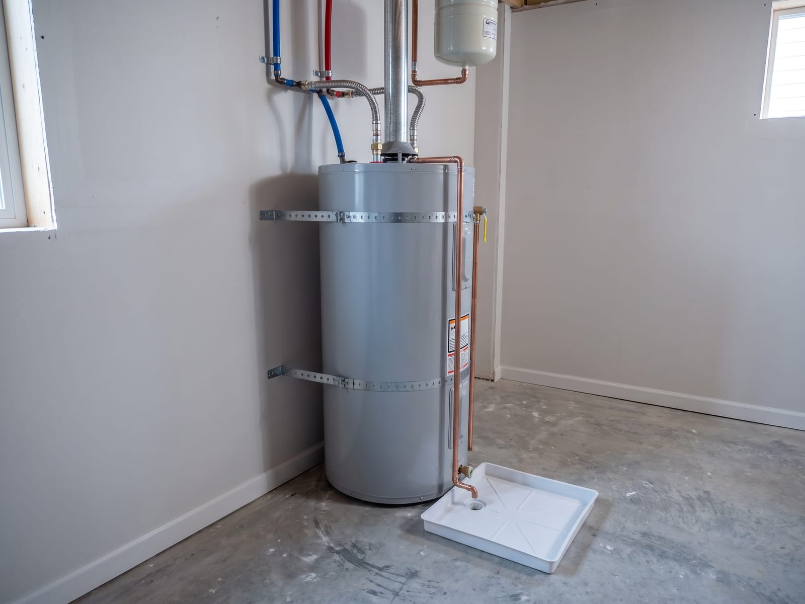 Tank water heater with an expansion tank, the T and P line piped down, drain pan and strapping